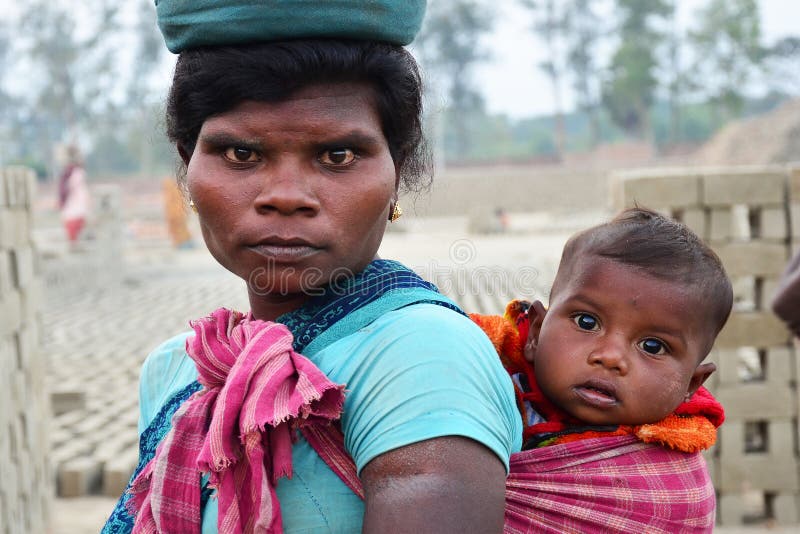 Kolkata 12 January 2019 ,A working woman carrying her son on her back in a factory ,Motherhood and care of a mother for her child. royalty free stock photography Kolkata 12 January 2019 ,A working woman carrying her son on her back in a factory ,Motherhood and care of a mother for her child. royalty free stock photography