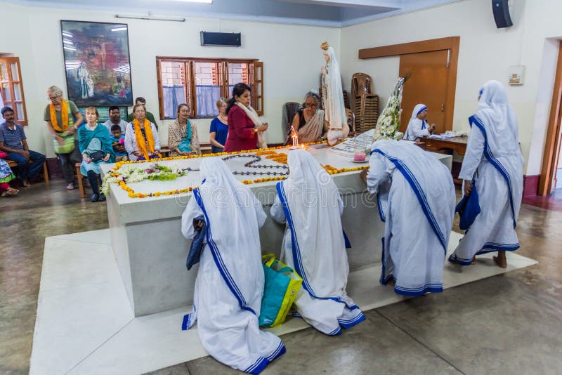 KOLKATA, ÍNDIA - 30 DE OUTUBRO DE 2016: As irmãs dos missionários da caridade rezam em Madre Teresa que o túmulo nas mães abriga fotografia de stock royalty free KOLKATA, ÍNDIA - 30 DE OUTUBRO DE 2016: As irmãs dos missionários da caridade rezam em Madre Teresa que o túmulo nas mães abriga fotografia de stock royalty free