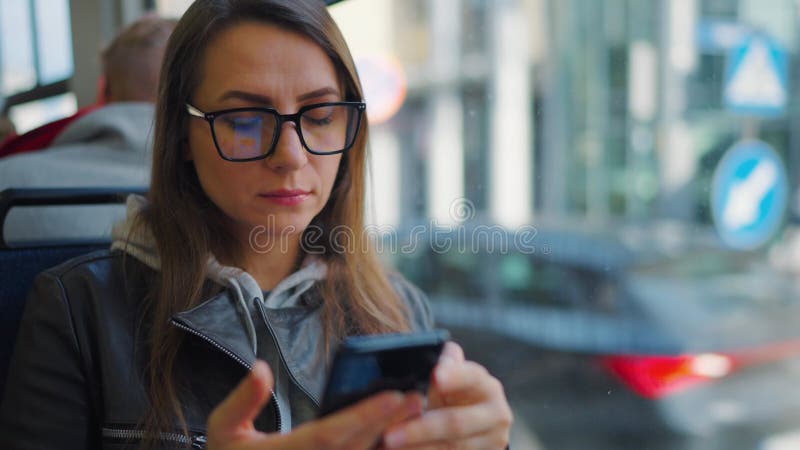 Kollektivtrafik. kvinnor i glasögon i brickor med smartphone slow motion