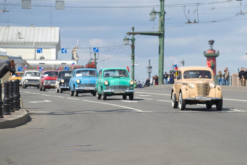 Kolonn av sovjetisk bil`-Moskvich ` av olika modeller på slottbron Den tredje årliga retro transporten ståtar i St Petersburg royaltyfria foton Kolonn av sovjetisk bil`-Moskvich ` av olika modeller på slottbron Den tredje årliga retro transporten ståtar i St Petersburg royaltyfria foton