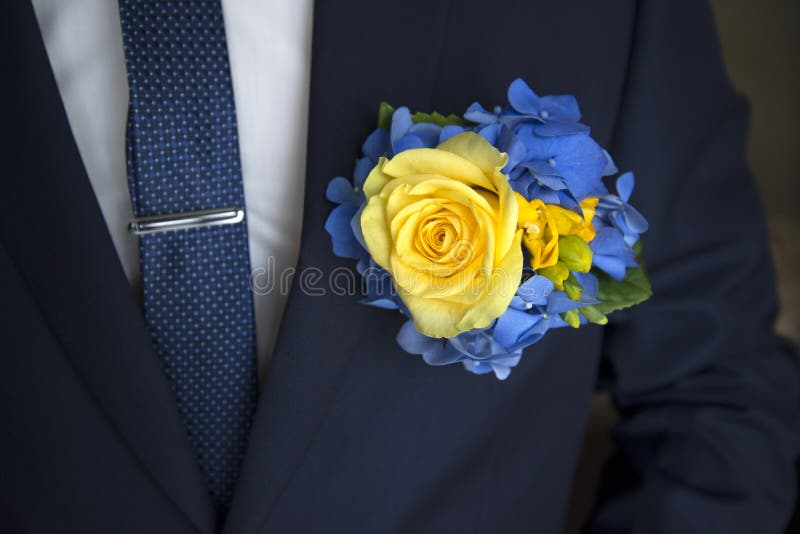 Kolor żółty róży boutonniere na czarnym kostiumu zdjęcia stock Kolor żółty róży boutonniere na czarnym kostiumu zdjęcia stock