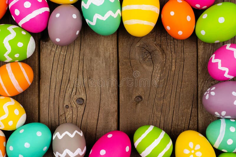 Kolorowa Wielkanocnego jajka rama przeciw nieociosanemu drewnianemu tłu