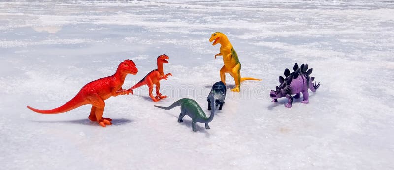 Colorful dinosaur toys standing on a salt floor. Photo taken in Salinas Grandes, Argentina. Colorful dinosaur toys standing on a salt floor. Photo taken in Salinas Grandes, Argentina.