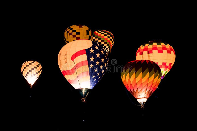 A group of glowing hot air balloons in the night sky at the International Balloon Fiesta in Albuquerque, New Mexico. A group of glowing hot air balloons in the night sky at the International Balloon Fiesta in Albuquerque, New Mexico