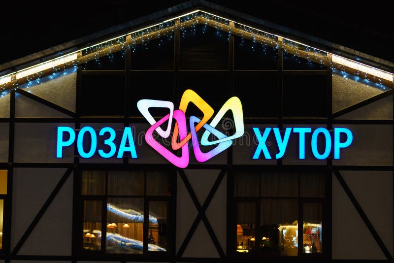 Kolorowy neonowy iluminujący Rosa Khutor halnego kurortu narciarski znak na budynek powierzchowności Rosa Khutor nocy logo tło fotografia royalty free Kolorowy neonowy iluminujący Rosa Khutor halnego kurortu narciarski znak na budynek powierzchowności Rosa Khutor nocy logo tło fotografia royalty free