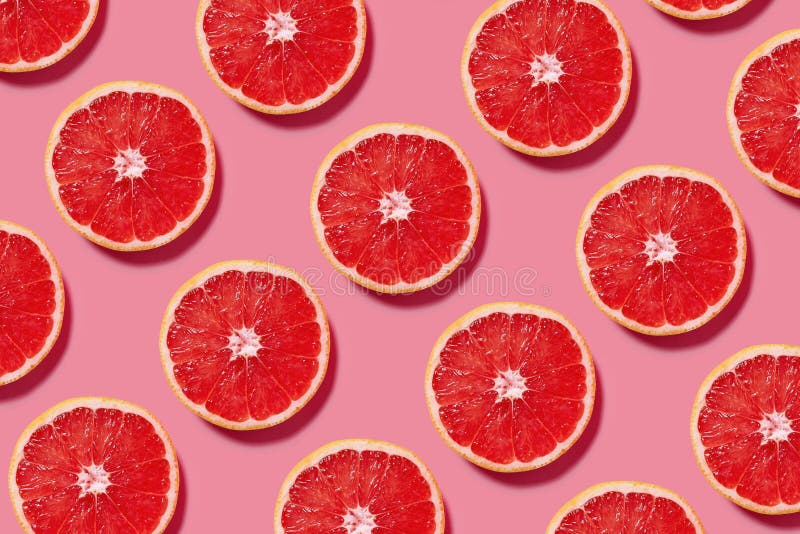 Kolorowy owoc wzór świezi grapefruitowi plasterki na różowym tle zdjęcia royalty free Kolorowy owoc wzór świezi grapefruitowi plasterki na różowym tle zdjęcia royalty free