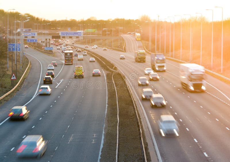 Kolorowy zmierzch przy M1 autostradą z ciężkim ruchem drogowym obraz stock Kolorowy zmierzch przy M1 autostradą z ciężkim ruchem drogowym obraz stock