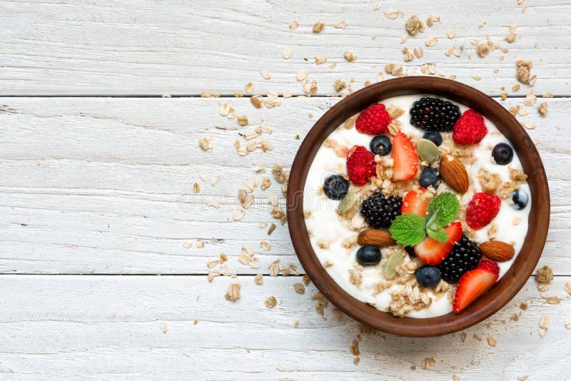 Kom Griekse yoghurt met granola, haver, bessen en noten voor gezond ontbijt