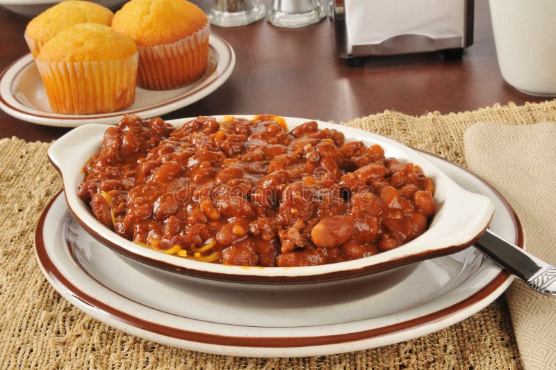 A bowl of chili con carne with cornbread muffins. A bowl of chili con carne with cornbread muffins