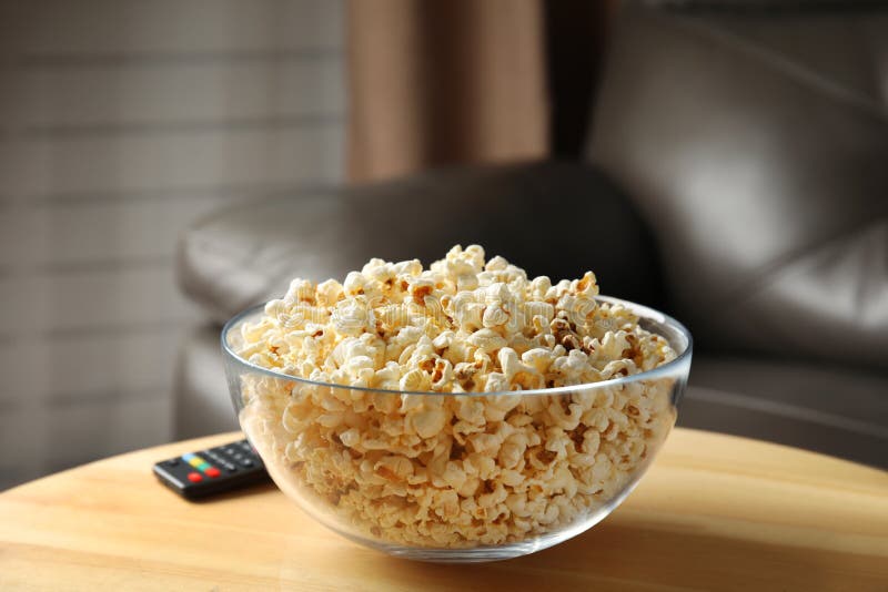 Kom van popcorn en TV ver op lijst stock foto's Kom van popcorn en TV ver op lijst stock foto's