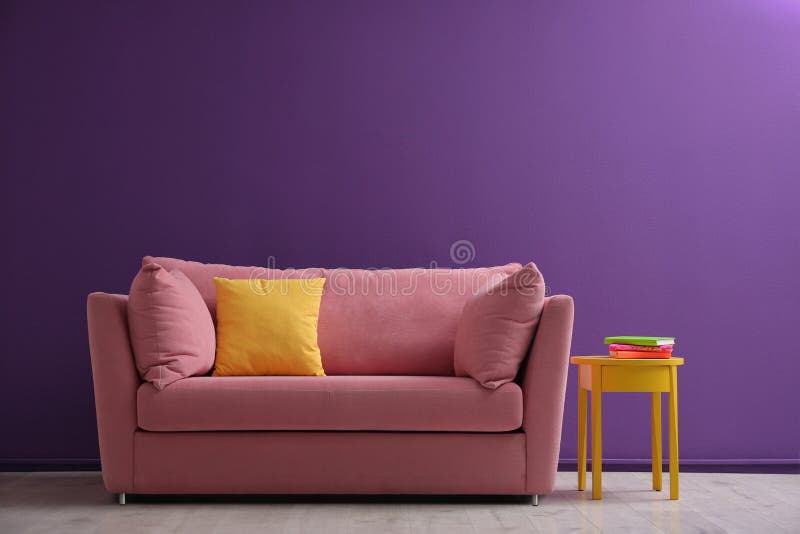 Comfortable pink sofa near purple wall in living room. Comfortable pink sofa near purple wall in living room