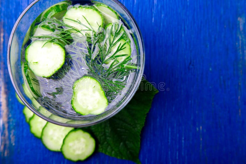 Komkommerwater in glas met dille op blauwe houten achtergrond Detox, dieet Hoogste mening De ruimte van het exemplaar stock foto's Komkommerwater in glas met dille op blauwe houten achtergrond Detox, dieet Hoogste mening De ruimte van het exemplaar stock foto's