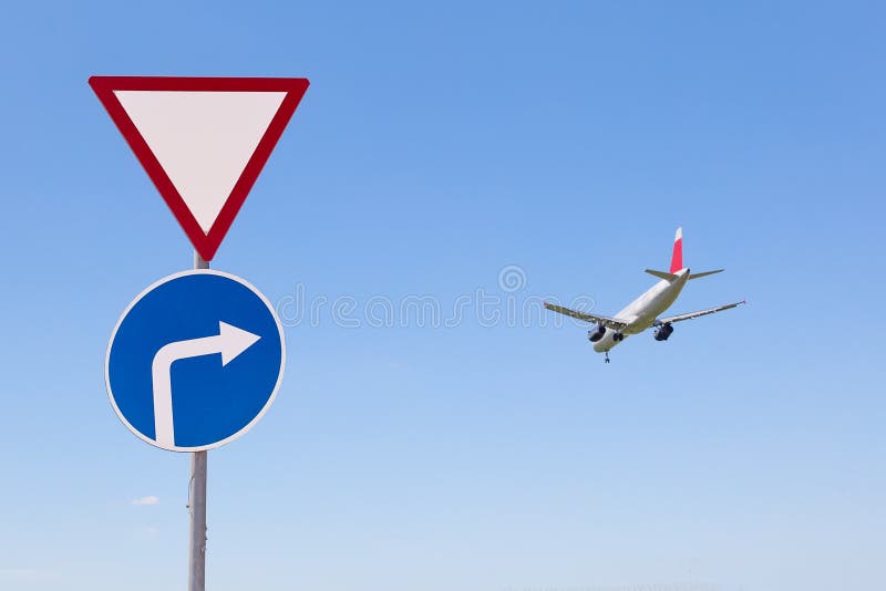Kommersiell trafikflygplan som landar nära vägmärken mot blå himmel Bild för lopp- eller affärsturbegrepp royaltyfri bild Kommersiell trafikflygplan som landar nära vägmärken mot blå himmel Bild för lopp- eller affärsturbegrepp royaltyfri bild