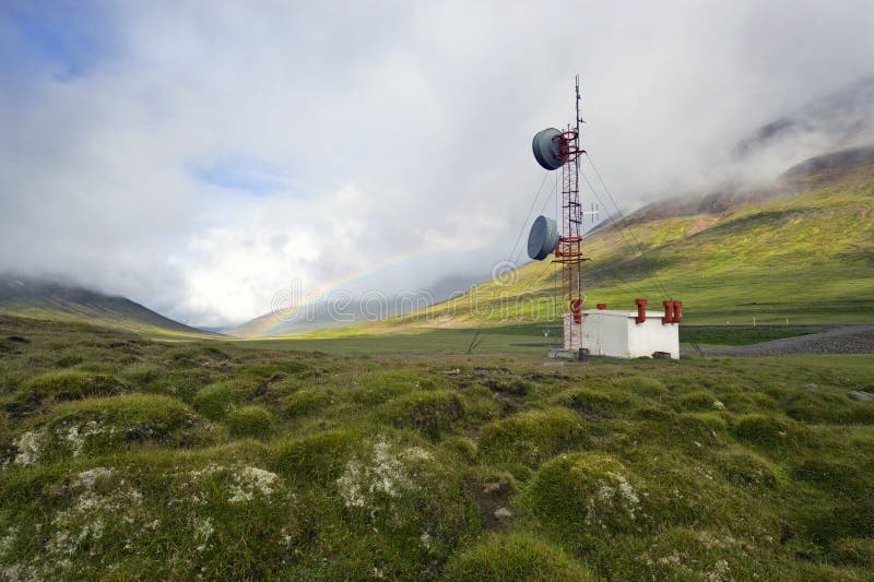 A communications tower in the Tundra of Iceland with a rainbow in the background. A communications tower in the Tundra of Iceland with a rainbow in the background