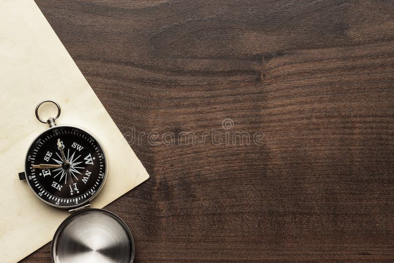 Kompas en oud document op de bruine houten lijst
