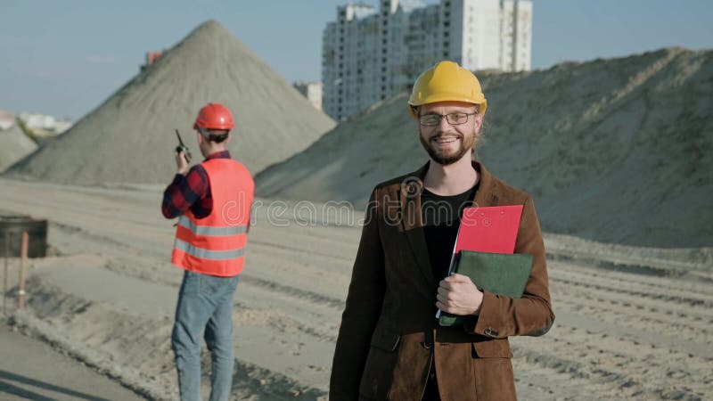 Kompetent arkitekt som kontrollerar arbetet på byggarbetsplatsen utanför royaltyfri foto