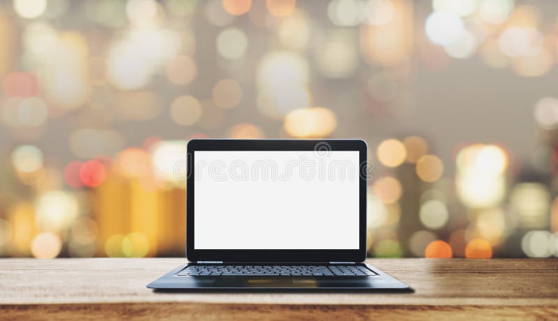 Komputerowego laptopu bielu pusty ekran na drewnianym biurku z rozmytym Bokeh światła tłem obraz royalty free
