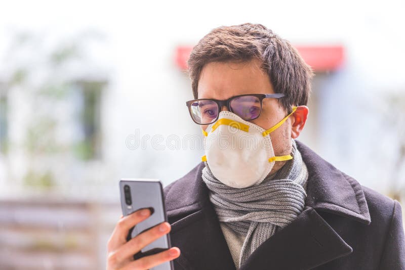 Koncepcja bezpieczeństwa spalin i korony. biznesmen noszący maskę twarzy, chroniący się i używający smartfona. na zewnątrz