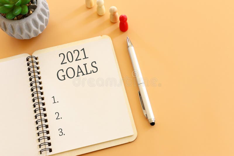 Koncepcja biznesowa listy celów top view 2021 z filiżanką kawy na notebooka nad drewnianym biurkiem.