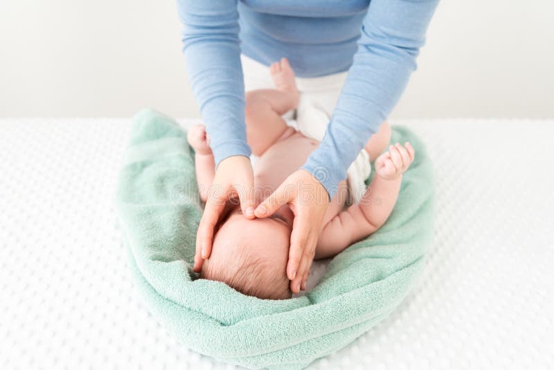 Koncepcja masażu twarzy dziecka Masseuse lub matka delikatnie stroiła twarz chłopca z dwiema rękami Zamknij wycięte zdjęcie fotografia royalty free