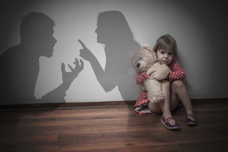 Koncepcja rozwodu Smutne dziecko siedzi na podłodze, kiedy rodzice się kłócą