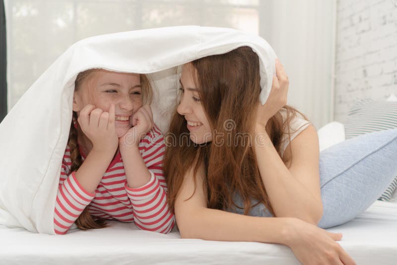 Happy family time concept. Mom and kid is playing together on the bed. Happy family time concept. Mom and kid is playing together on the bed