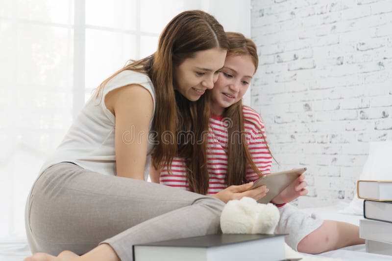 Happy family time concept. Mom and kid are playing together on the bed. Happy family time concept. Mom and kid are playing together on the bed