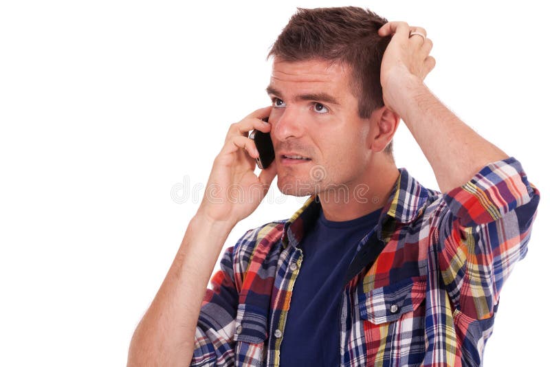 Konfuser junger Mann am Telefon lizenzfreie stockfotografie Konfuser junger Mann am Telefon lizenzfreie stockfotografie