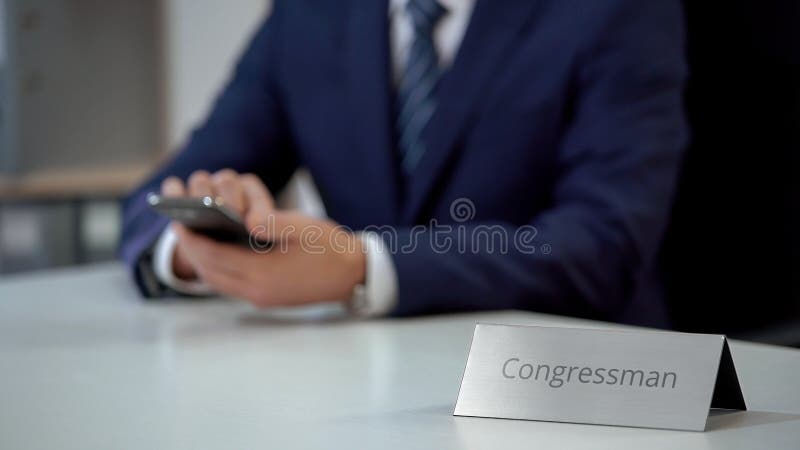 Kongressabgeordnetes, das letzte Politiknachrichten auf Smartphone, Untersuchungssituation überprüft lizenzfreie stockbilder Kongressabgeordnetes, das letzte Politiknachrichten auf Smartphone, Untersuchungssituation überprüft lizenzfreie stockbilder