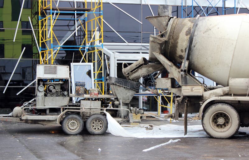 concrete pump and concrete mixer to work together to pouring cement floors in the shopping center for repair. concrete pump and concrete mixer to work together to pouring cement floors in the shopping center for repair