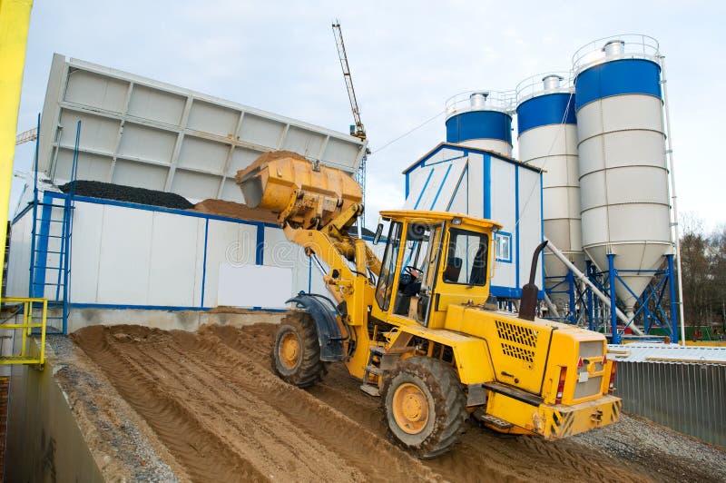 Front-end loader loading with sand bunker of Stationary Concrete Batching Plant. Front-end loader loading with sand bunker of Stationary Concrete Batching Plant