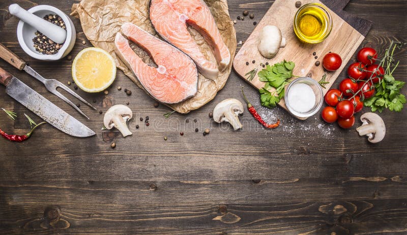 Konkurrieren Lachssteak zwei auf Papier mit Pfeffer, Kräutern, einem Messer und Gabel, Butter, Kräuter, Kirschtomaten auf die höl stockbild Konkurrieren Lachssteak zwei auf Papier mit Pfeffer, Kräutern, einem Messer und Gabel, Butter, Kräuter, Kirschtomaten auf die höl stockbild