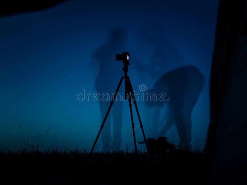 Konstnärligt långt exponeringsfoto av en fotograf i handling Åtskilliga konturer och en kameraFN-tripod royaltyfri fotografi Konstnärligt långt exponeringsfoto av en fotograf i handling Åtskilliga konturer och en kameraFN-tripod royaltyfri fotografi
