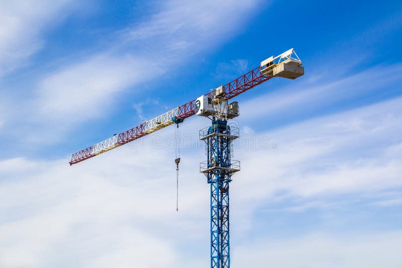 Konstruktionskran för hög elevator med vita, röda och blåa färger mot en blå himmel royaltyfri bild Konstruktionskran för hög elevator med vita, röda och blåa färger mot en blå himmel royaltyfri bild