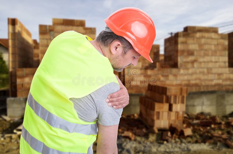 Constructor suffering from shoulder pain or having an accident on outdoor construction workplace. Constructor suffering from shoulder pain or having an accident on outdoor construction workplace