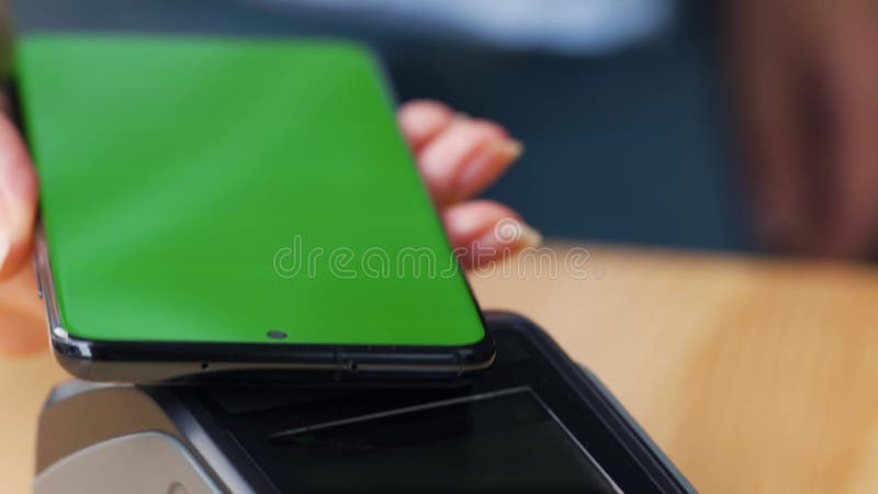 Kontaktlös betalning med smartphone med grön mockup-skärm. trådlöst betalningsbegrepp. sluten kvinna som använder