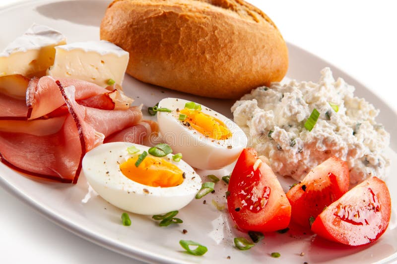 Kontinentales Frühstück gekochte Eier, Tomaten aus weißem Käse und Brötchen auf weißem Hintergrund stockfoto