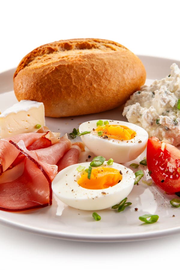 Kontinentales Frühstück gekochte Eier, Tomaten aus weißem Käse und Brötchen auf weißem Hintergrund stockfotos