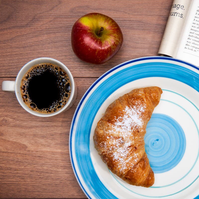 Kontinentales Frühstück mit Kaffee, frischen Hörnchen, Frucht und guter Zeitschrift lizenzfreies stockbild Kontinentales Frühstück mit Kaffee, frischen Hörnchen, Frucht und guter Zeitschrift lizenzfreies stockbild