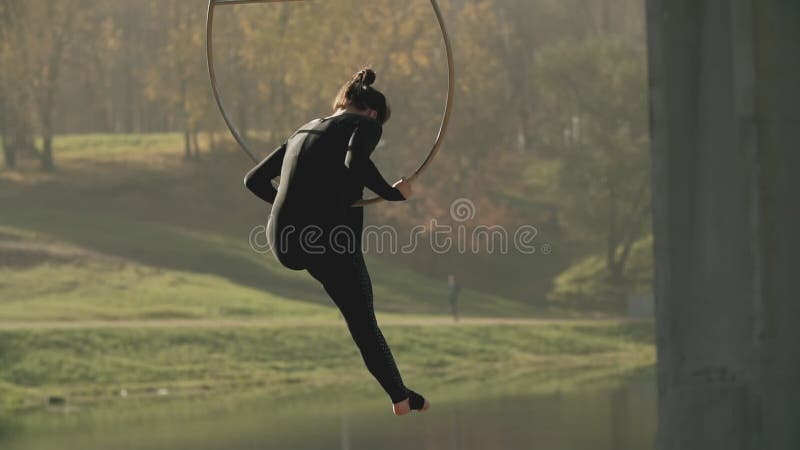 Kontur av kvinnan som utomhus gör några akrobatiska beståndsdelar på flyg- beslag
