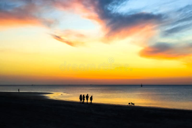 Konturer av folk som går på stranden på solnedgången Episk dramatisk solnedg?ng royaltyfri bild Konturer av folk som går på stranden på solnedgången Episk dramatisk solnedg?ng royaltyfri bild