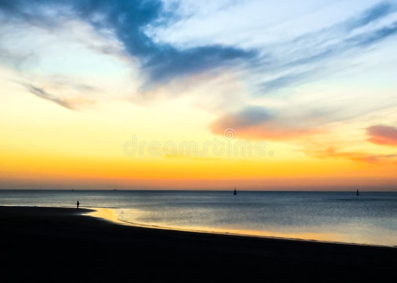 Konturer av folk som går på stranden på solnedgången Episk dramatisk solnedg?ng fotografering för bildbyråer Konturer av folk som går på stranden på solnedgången Episk dramatisk solnedg?ng fotografering för bildbyråer