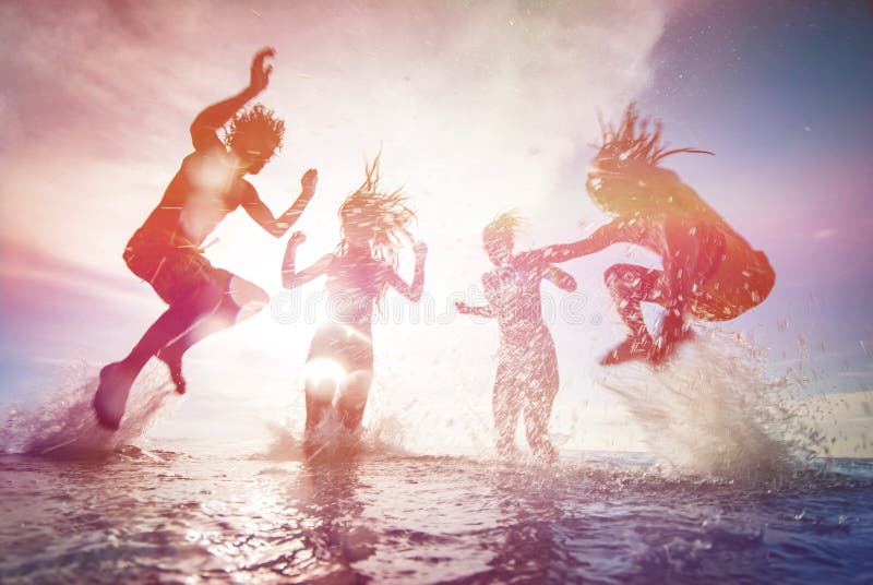 Silhouettes of happy young people jumping in sea at the beach on sunset. Silhouettes of happy young people jumping in sea at the beach on sunset