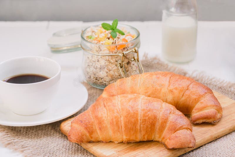 Kontynentalny tradycyjny śniadaniowy Croissant, filiżanka kawy i granola, Na białym tle na brezentowej pielusze, fotografia royalty free Kontynentalny tradycyjny śniadaniowy Croissant, filiżanka kawy i granola, Na białym tle na brezentowej pielusze, fotografia royalty free