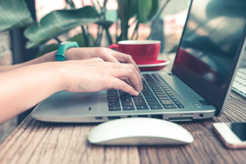 Konzentrieren Sie sich auf die Frauenhand unter Verwendung des Laptops und suchen und überprüfen und Informationen an der Kaffees stockfoto Konzentrieren Sie sich auf die Frauenhand unter Verwendung des Laptops und suchen und überprüfen und Informationen an der Kaffees stockfoto
