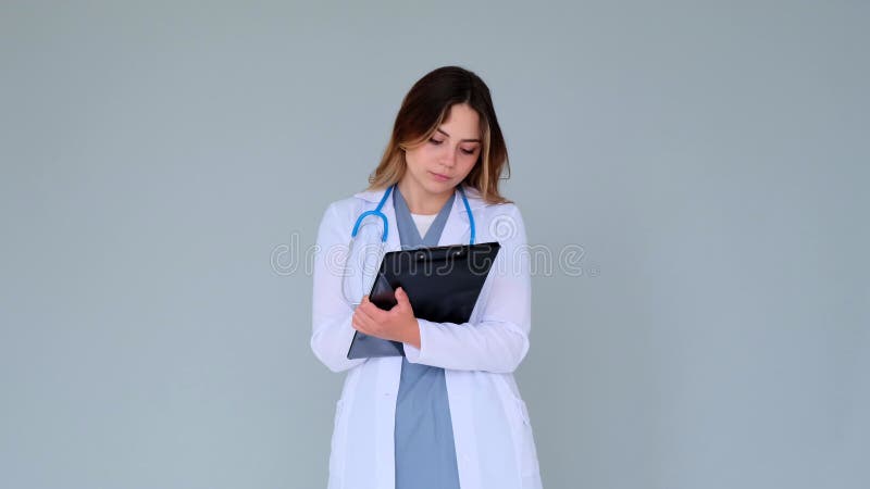 Konzentrierter Arzt oder Krankenpfleger im Notepad auf grauem Hintergrund stock video