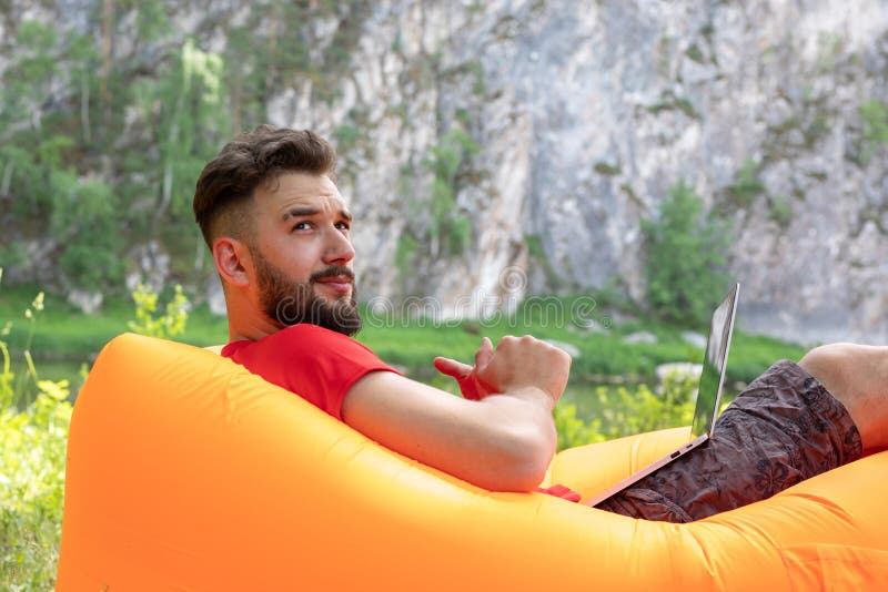 Konzept der Fernarbeit, freiberufliche Tätigkeit Workaholische Arbeit am Tag frei, im Urlaub Geschäftsmann arbeitet im Park mit L lizenzfreie stockbilder Konzept der Fernarbeit, freiberufliche Tätigkeit Workaholische Arbeit am Tag frei, im Urlaub Geschäftsmann arbeitet im Park mit L lizenzfreie stockbilder