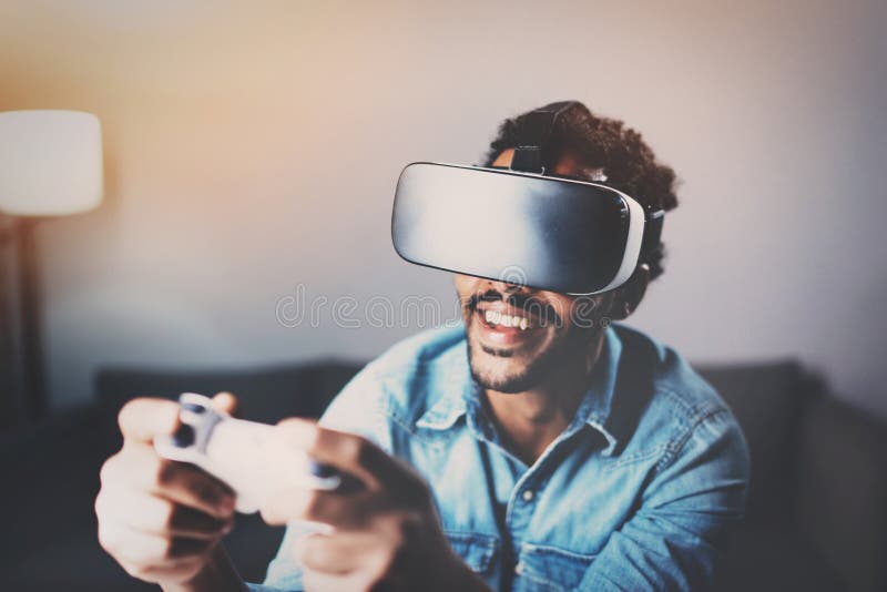 Konzept der Technologie, des Spiels, der Unterhaltung und der Leute Afrikanischer Mann, der Glasvideospiel der virtuellen Realitä