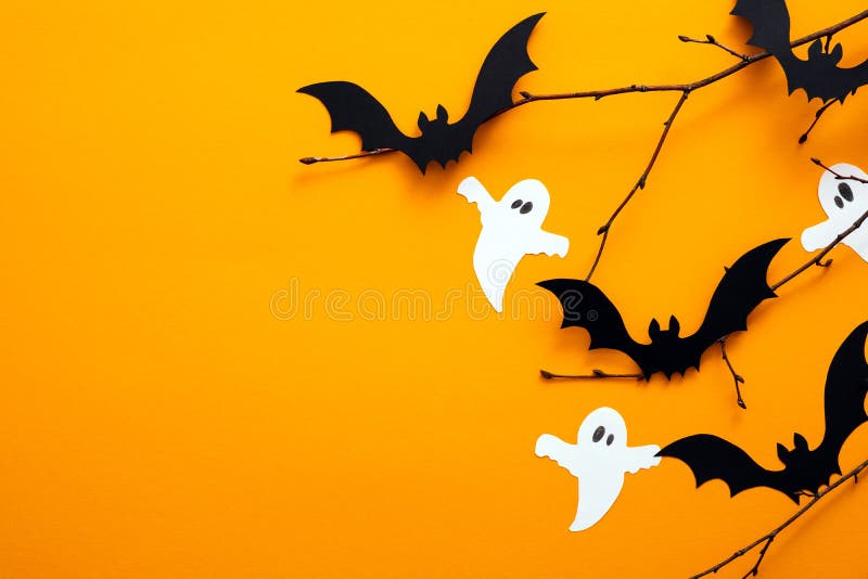 Konzept des glücklichen Halloween-Tages. Halloween Dekorationen Papier Geister Fledermäuse auf orange Hintergrund. flacher Kopierb