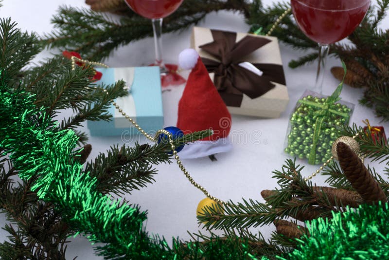 Konzept des neuen Jahres mit den schneebedeckten Kiefernblättern, bunt und zwei Gläsern Wein auf weißem Hintergrund stockbild Konzept des neuen Jahres mit den schneebedeckten Kiefernblättern, bunt und zwei Gläsern Wein auf weißem Hintergrund stockbild